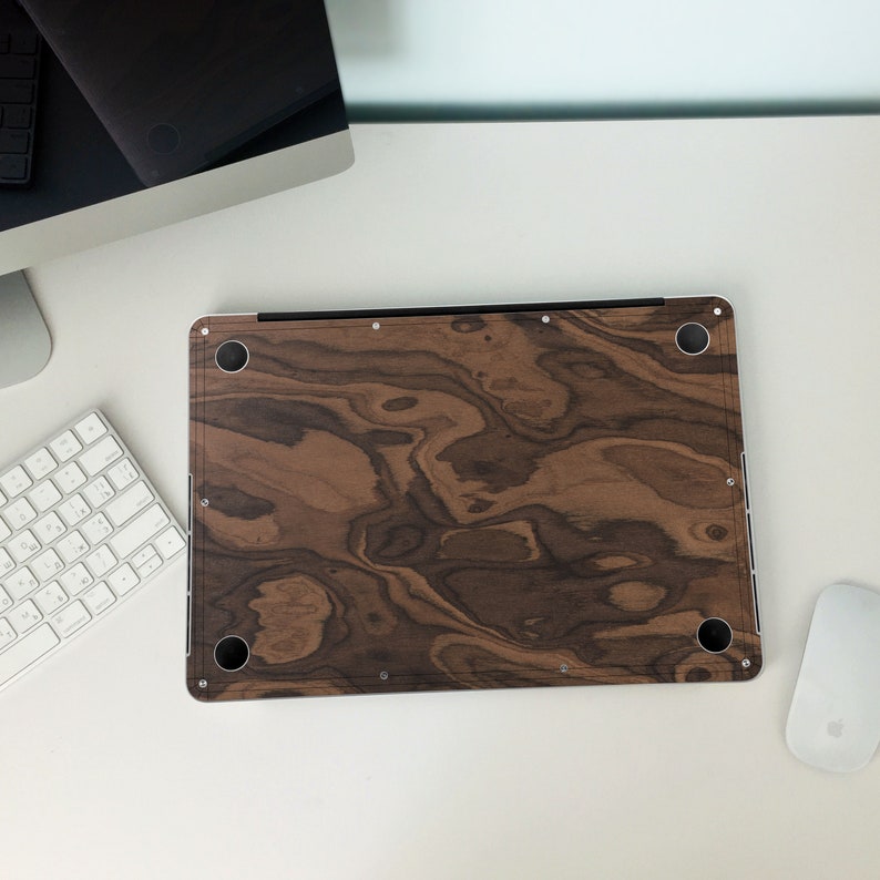 May include: A brown wood laptop skin with a dark wood grain pattern. The skin has a smooth, matte finish and is designed to protect the laptop from scratches and wear.