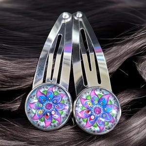 May include: Two silver hair clips with colorful mandala designs. The mandalas are purple, blue, green, red, and yellow.