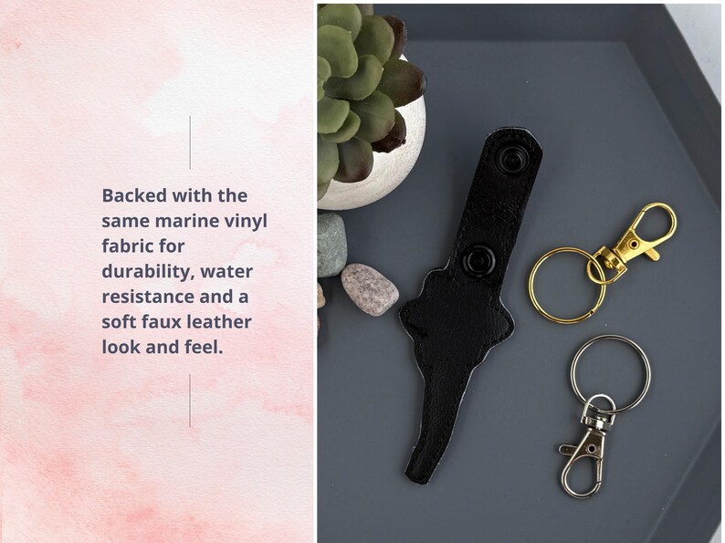 May include: Black leather key chain with two metal snap hooks. One hook is gold and the other is silver. The key chain is backed with marine vinyl fabric for durability and water resistance.