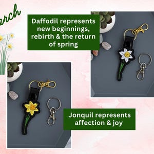 May include: Two keychains with embroidered daffodils. The keychain on the left features a yellow daffodil and the keychain on the right features a white daffodil. Both keychains have black leather straps and gold metal rings.