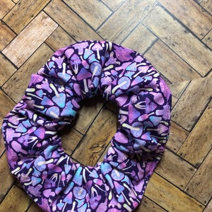 May include: Purple scrunchie with a white and light purple mushroom pattern.
