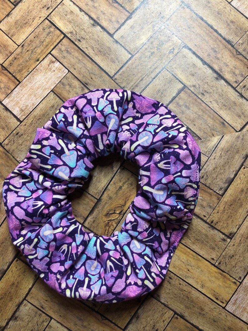May include: Purple scrunchie with a white and light purple mushroom pattern.