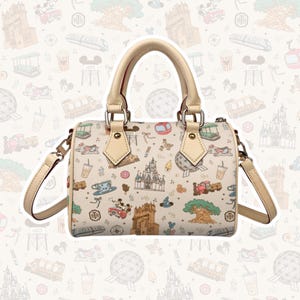 May include: Cream-colored handbag with a repeating pattern of theme park icons, including castles, teacups, and Mickey Mouse. The bag has a beige handle and shoulder strap, with gold-colored hardware. The bag has the text "HTH" on it.