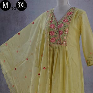 May include: A light yellow tunic with a V-neckline featuring pink and green floral embroidery, three-quarter sleeves, and a matching sheer dupatta with small red floral accents. The text M to 3XL is visible in the upper left corner.