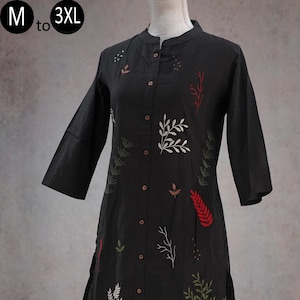 May include: A black long-sleeved tunic with a mandarin collar and a front button placket. The garment features embroidered botanical patterns in white, red, and olive green. The text M to 3XL is visible in the upper left corner of the image.