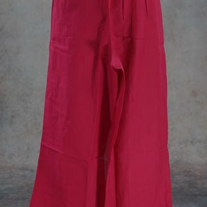 Puede incluir: Pantalones rojos de pierna ancha. Los pantalones tienen una cintura alta y un ajuste relajado. La tela parece ser un material ligero, adecuado para climas c&aacute;lidos. Los pantalones se muestran en un maniqu&iacute;.