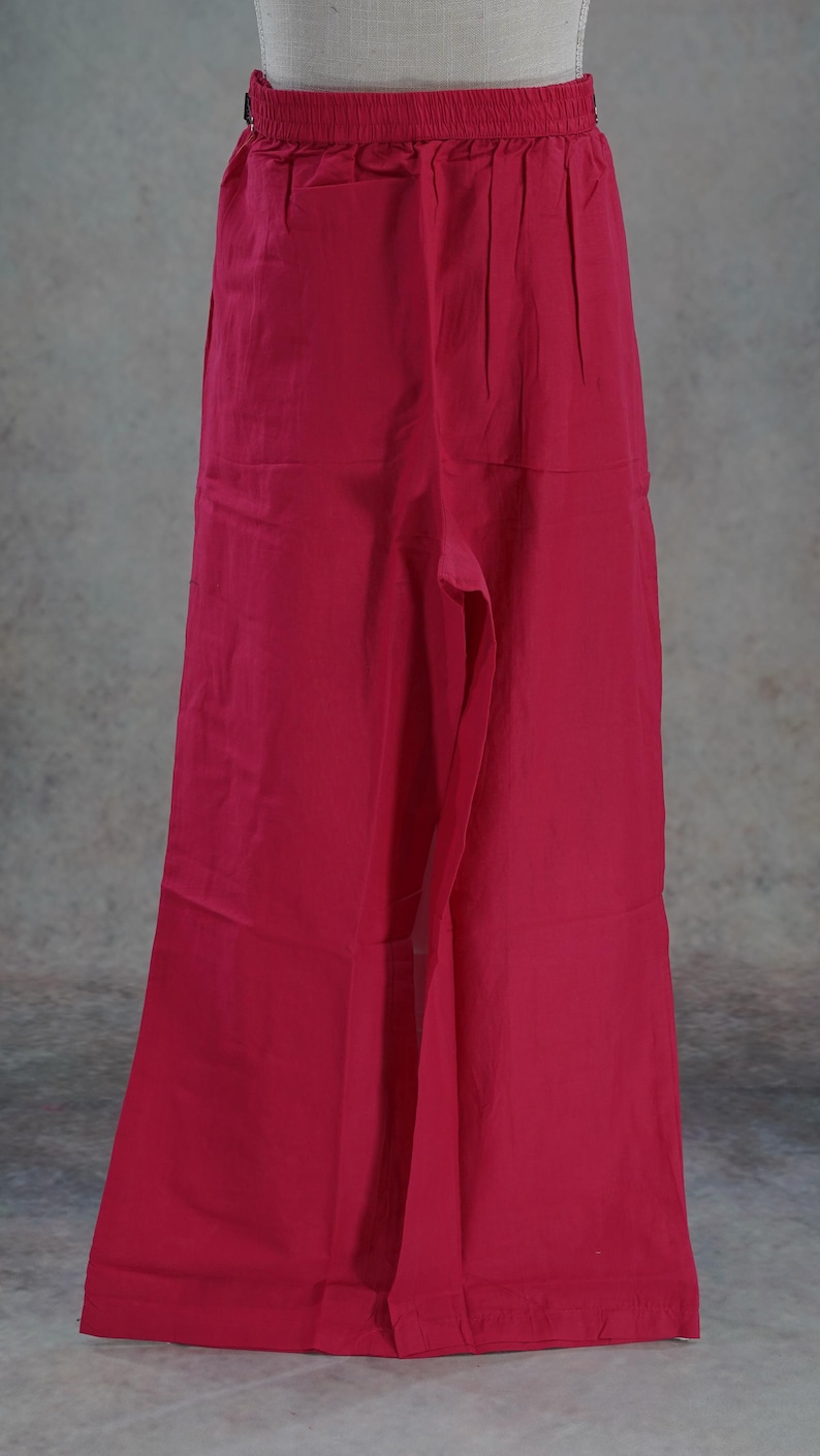 Puede incluir: Pantalones rojos de pierna ancha. Los pantalones tienen una cintura alta y un ajuste relajado. La tela parece ser un material ligero, adecuado para climas c&aacute;lidos. Los pantalones se muestran en un maniqu&iacute;.