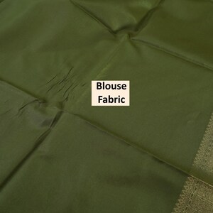 Puede incluir: Tela de blusa verde oliva con un borde dorado y el texto "Blouse Fabric". La tela est&aacute; doblada, mostrando una superficie texturizada. El borde tiene un dise&ntilde;o detallado con detalles dorados.