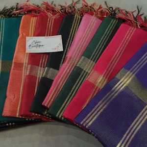 May include: A selection of vibrant scarves, each featuring gold stripes and fringed ends. The scarves are displayed in shades of blue, green, orange, red, pink, and purple. The label reads "Chic Boutique".