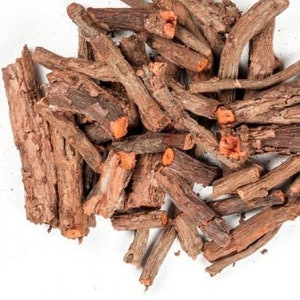 May include: A pile of brown, dried roots with a reddish-orange interior, likely a herbal product. The roots vary in size and shape, with some showing bark and others cut ends. The image is shot against a white background, highlighting the natural colors and textures.