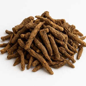 May include: A pile of dried, brown, root-like pieces against a white background. The pieces have a rough, textured appearance and vary in size and shape. The image is well-lit, highlighting the natural color and texture of the product.