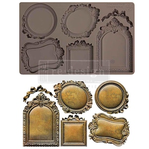May include: A brown silicone mold with various ornate frame designs. The mold includes oval, rectangular, and arched shapes, along with several finished frames in a metallic gold color. The text "ITEM NO. 677619 ORNATE MINIS" is visible.