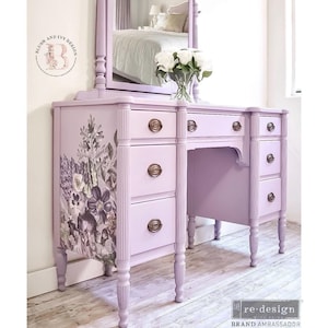 May include: A lavender vanity with a floral design on the side. The vanity has six drawers and a mirror with a decorative top. The vanity has turned legs and brass hardware.