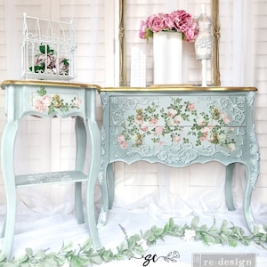 May include: Two vintage-style side tables with a light blue finish and floral designs. The larger table has two drawers and the smaller table has a shelf. Both tables have gold accents and are decorated with pink roses.