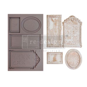 May include: A rectangular silicone mold in a muted mauve color featuring various recessed frame and plaque designs, alongside four finished off-white, textured resin castings depicting a zebra, butterflies, a small figure, and floral arrangements.