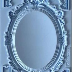 May include: A light blue silicone mold featuring an oval mirror frame and decorative corner pieces. The frame has ornate detailing, and the mold includes smaller, matching decorative elements. The mold is designed for crafting and DIY projects.