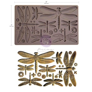 May include: A gray silicone mold featuring various dragonfly designs, measuring 8 inches by 5 inches. The dragonfly designs include detailed wings and mechanical-style accents. Below, a display of bronze-colored dragonfly embellishments.