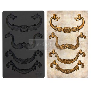 May include: A black silicone mold with four different ornate door handle designs. The mold is next to a sheet of paper with the same four designs in gold.
