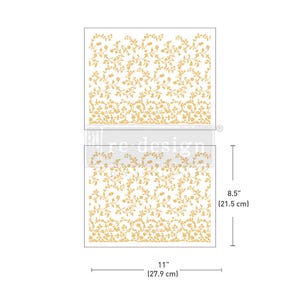 May include: Two rectangular stencils with a floral vine design. The stencils are 11 inches (27.9 cm) wide and 8.5 inches (21.5 cm) tall. The floral pattern is in a gold color, and the background is white. The stencils are labeled with the text "re design".