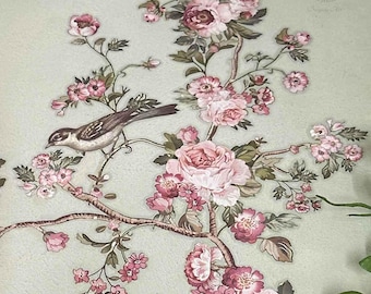 Puede incluir: Un delicado diseño floral con rosas rosas y pequeñas flores blancas sobre un fondo verde claro. Un pequeño pájaro marrón se posa en una rama con hojas verdes.