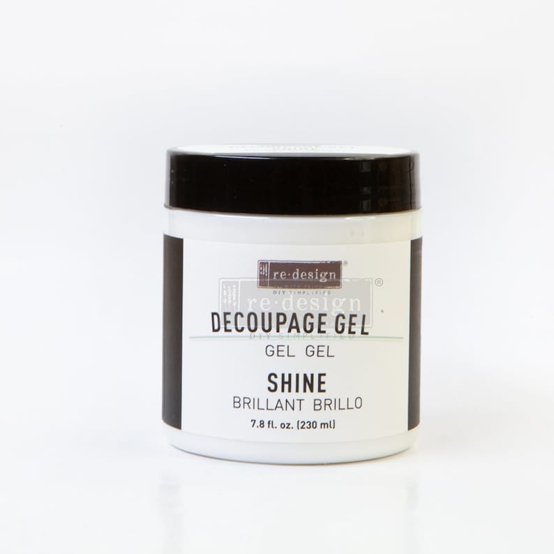 May include: A white jar with a black lid labeled "re-design Decoupage Gel Gel Gel Shine Brillant Brillo 7.8 fl. oz. (230 ml)"