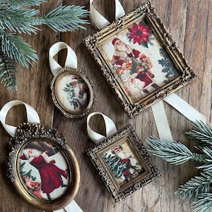 May include: Four decorative Christmas ornaments featuring vintage-style Santa Claus illustrations inside ornate, antique-gold colored frames. Each frame is equipped with a cream-colored satin ribbon loop for hanging, showcasing detailed holiday imagery.