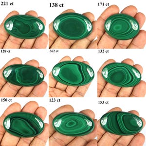 May include: Nine oval-shaped malachite gemstones with varying patterns and shades of green. Each stone is held in a hand and labeled with a carat weight, ranging from 123 ct to 362 ct. The polished stones display unique swirling designs.