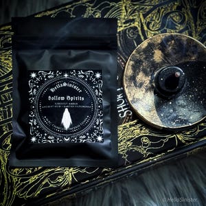 Handmade charcoal incense cones scattered beside black packaging labeled “Hollow Spirits” by HellaSinister, featuring oud, patchouli, and amber incense cones displayed on a dark gothic background.