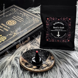 Charcoal incense cone burning on a ceramic incense holder, with a black bag labeled “Devils Croft” pumpkin and clove incense cones by HellaSinister, photographed on a dark gothic background with vintage occult book props.