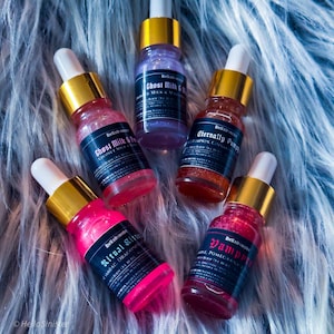 Vegan shimmery perfume oil samples in pink, purple, and orange hues on faux fur – HellaSinister handmade body oil