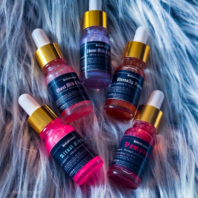 Vegan shimmery perfume oil samples in pink, purple, and orange hues on faux fur – HellaSinister handmade body oil