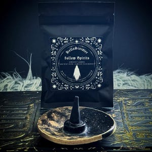 Handmade charcoal incense cones scattered beside black packaging labeled “Hollow Spirits” by HellaSinister, featuring oud, patchouli, and amber incense cones displayed on a dark gothic background.