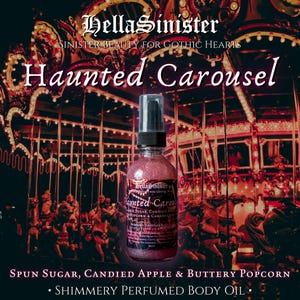 May include: A shimmery, pink-toned body oil spray bottle with a black cap, labeled "Haunted Carousel." The background features a carousel with illuminated horses and the text "HellaSinister." The scent is described as spun sugar, candied apple, and buttery popcorn.