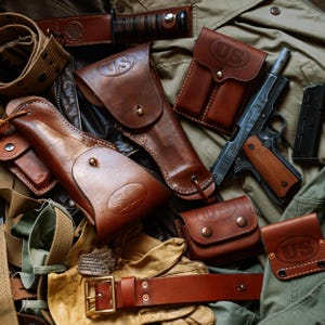 Puede incluir: Una colección de equipo militar de cuero marrón que incluye dos fundas, una bolsa doble para cargadores, una pequeña bolsa utilitaria y un cinturón, todos grabados con US. Se incluye una pistola semiautomática con empuñaduras de madera.
