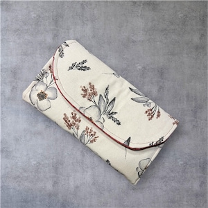 Cartera floral con múltiples ranuras para tarjetas de crédito, un anillo en D para pulsera (se vende por separado), un bolsillo con cierre y un bolsillo para teléfono celular en la parte posterior.