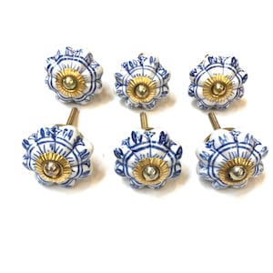 May include: Set of six blue and white ceramic cabinet knobs with gold accents. Each knob features a floral design.