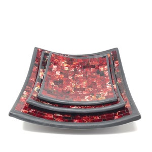 May include: Set of three red and black mosaic serving trays. The trays are square with rounded corners and have a slightly curved shape. The mosaic tiles are small and create a textured surface.