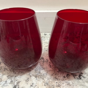 Puede incluir: Dos copas de vino de vidrio rojo con una superficie texturizada.