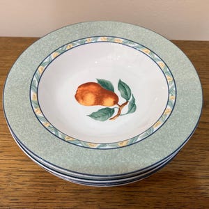 Pode incluir: Um conjunto de três tigelas de cerâmica verde e branca com um design de pêra. As tigelas têm uma borda verde e um interior branco com uma borda amarela e verde.