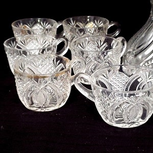 May include: A set of eight clear glass punch cups with a cut glass design. The cups have a gold rim and are ideal for serving punch or other beverages.