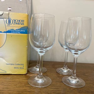 K&ouml;nnte beinhalten: Drei klare Weingl&auml;ser f&uuml;r Wei&szlig;wein auf einer Holzoberfl&auml;che. Die Gl&auml;ser stammen aus der Lexington Collection von Schott Zwiesel Connoisseur's Crystal.