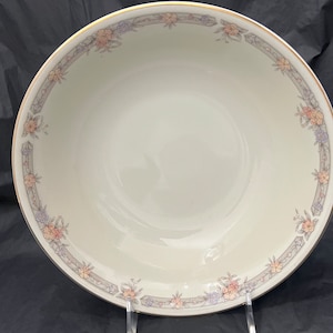 May include: A white ceramic serving bowl with a gold rim and a floral pattern in shades of pink, purple, and gray.