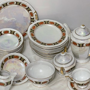 May include: A set of white porcelain teacups, saucers, and plates with gold trim and floral designs. The set includes a teapot, creamer, and sugar bowl.
