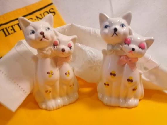 Pair of mid-century ceramic figurines of 2 glamorous cats. White-glazed china with hand-painted detailing and satin bows. Circa 60s or 70s.