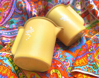 Pair of yellow Tupperware Harvest Gold creamers or milk jugs with stylised wheat motif, circa 1970s.