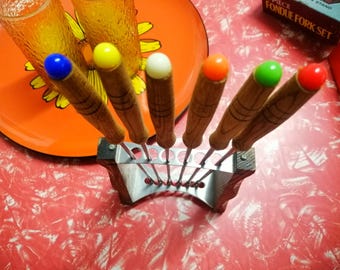 Set of 6 vintage fondue forks with metal and wooden stand in original box, various colour terminals, Japanese stainless steel circa 1960s.