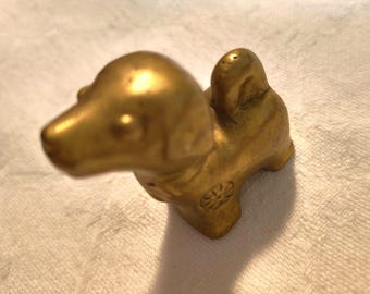 Mid-century novelty cast brass dog, stylised beagle or Jack Russell terrier, with stamped flowers and bow, circa 1960s.