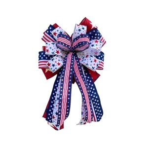 May include: A red, white, and blue bow with stars and stripes. The bow is made of ribbon and is tied in a knot. It is a patriotic decoration.