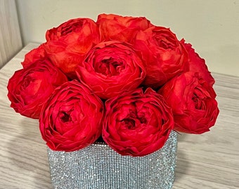 May include: A bouquet of red roses arranged in a silver sparkly vase. The vase is covered in rhinestones.