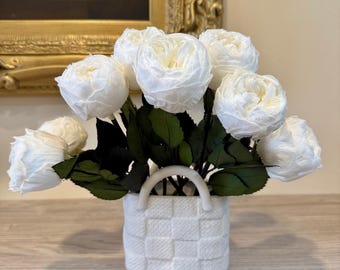 May include: A bouquet of white silk roses arranged in a white ceramic basket with a woven pattern.